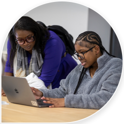 Two dae students working on laptop in classroom
