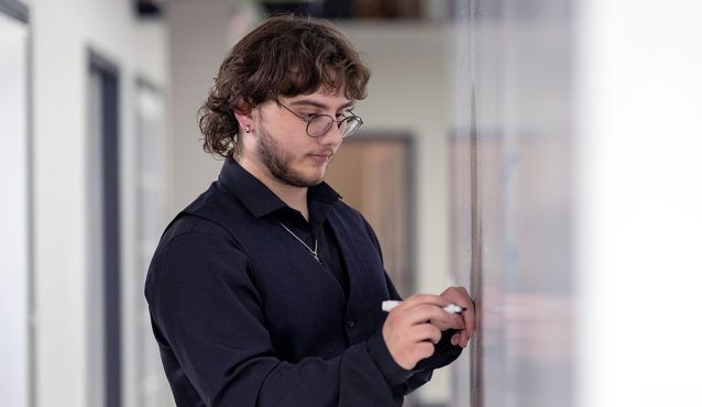 dae instructor writing on white board in classroom